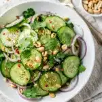 Crisp Thai cucumber salad with fresh cilantro and roasted peanuts in a bowl.