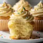Classic vanilla cupcakes with creamy buttercream frosting and a pastel sprinkle.