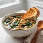 Hearty Italian white bean soup with spinach in a rustic tomato broth.
