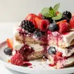 Layered berry icebox cake slice with graham cracker and cream