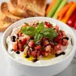 Creamy bruschetta dip with tomatoes basil and garlic served with toasted bread