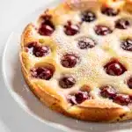 Close-up cherry clafoutis with powdered sugar on rustic table