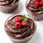 Rich dark chocolate mousse cups with raspberries and cream