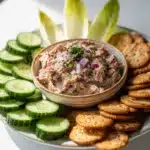 Creamy tuna spread appetizer with dill served on cucumber rounds and crackers.