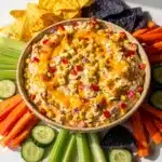 Creamy crockpot corn dip with cheese and peppers served with tortilla chips.