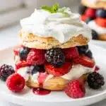 Fresh Berry Shortcakes on rustic board with juicy berries.