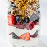 Layered Greek yogurt parfait with mixed berries and granola.