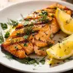 Grilled lemon herb salmon with crispy crust and moist flaky interior.