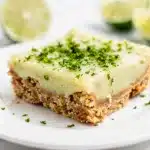 Creamy key lime pie bars with a buttery crumb crust on a marble slab.
