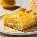 Fresh lemon bars with powdered sugar on rustic wooden board