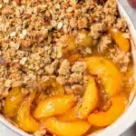 Peach crisp with oat topping and vanilla ice cream.