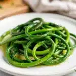 Sauteed garlic scapes are crispy tender and vibrant in this close up food photo