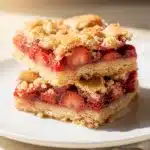 Strawberry shortcake bars with creamy filling and crumbly buttery topping.