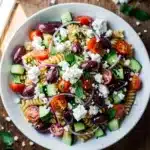 Greek pasta salad with rotini, feta, and olives in bowl.